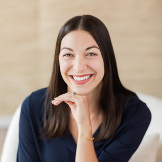 Woman sitting on a couch with a neutral background